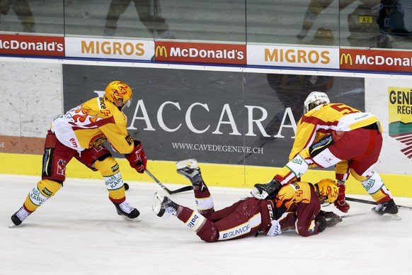 Geneve-Servette&#039;s center Tanner Richard, center, falls between Tigers&#039; forward Antti Erkinjuntti, of Finland, left, and Tigers&#039; defender Yves Mueller, right, during a National League re ...