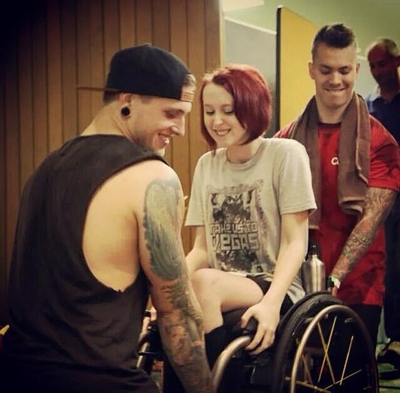 Bandmitglieder tragen Frau im Rollstuhl