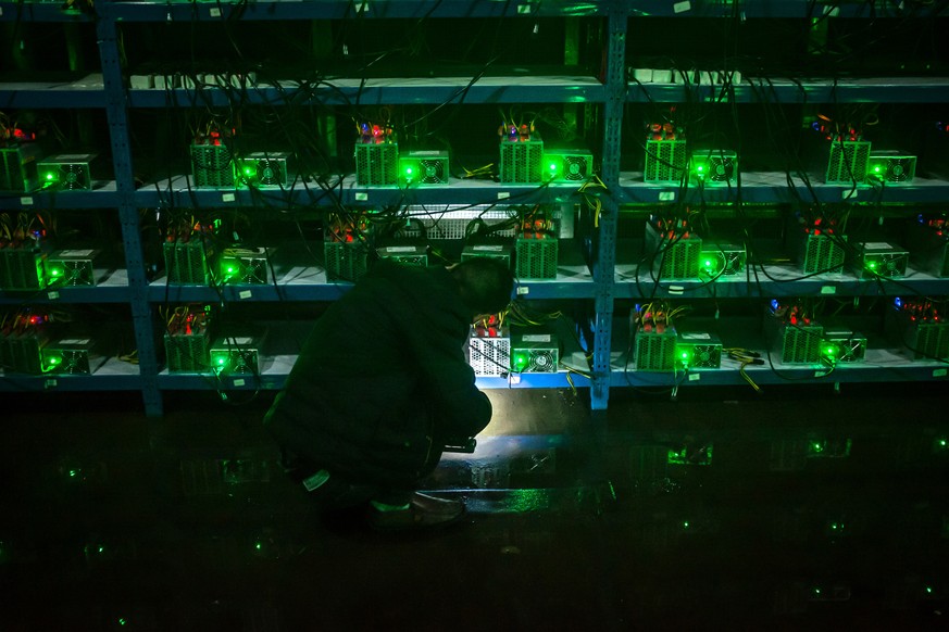 epa08402092 (23/50) Bitcoin miner Huang inspects a malfunctioning mining machine during his night shift at the Bitcoin mine in Sichuan Province, China, 26 September 2016 (reissued 05 May 2020). Green  ...