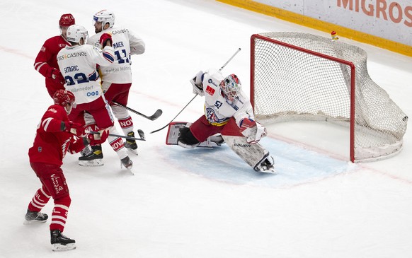 Lausanne&#039;s defender Robin Grossmann, left, scores the 1:0 against Lakers&#039; goaltender Noel Bader, right, during a National League regular season game of the Swiss Championship between Lausann ...