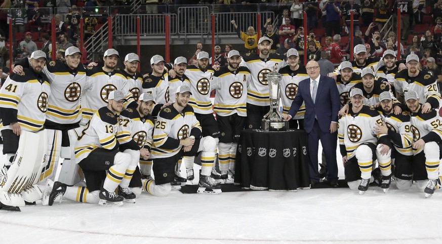 Boston Bruins players pose with the Prince of Wales trophy and Bill Daly, deputy commissioner of the National Hockey League, following Game 4 of the NHL hockey Stanley Cup Eastern Conference finals ag ...