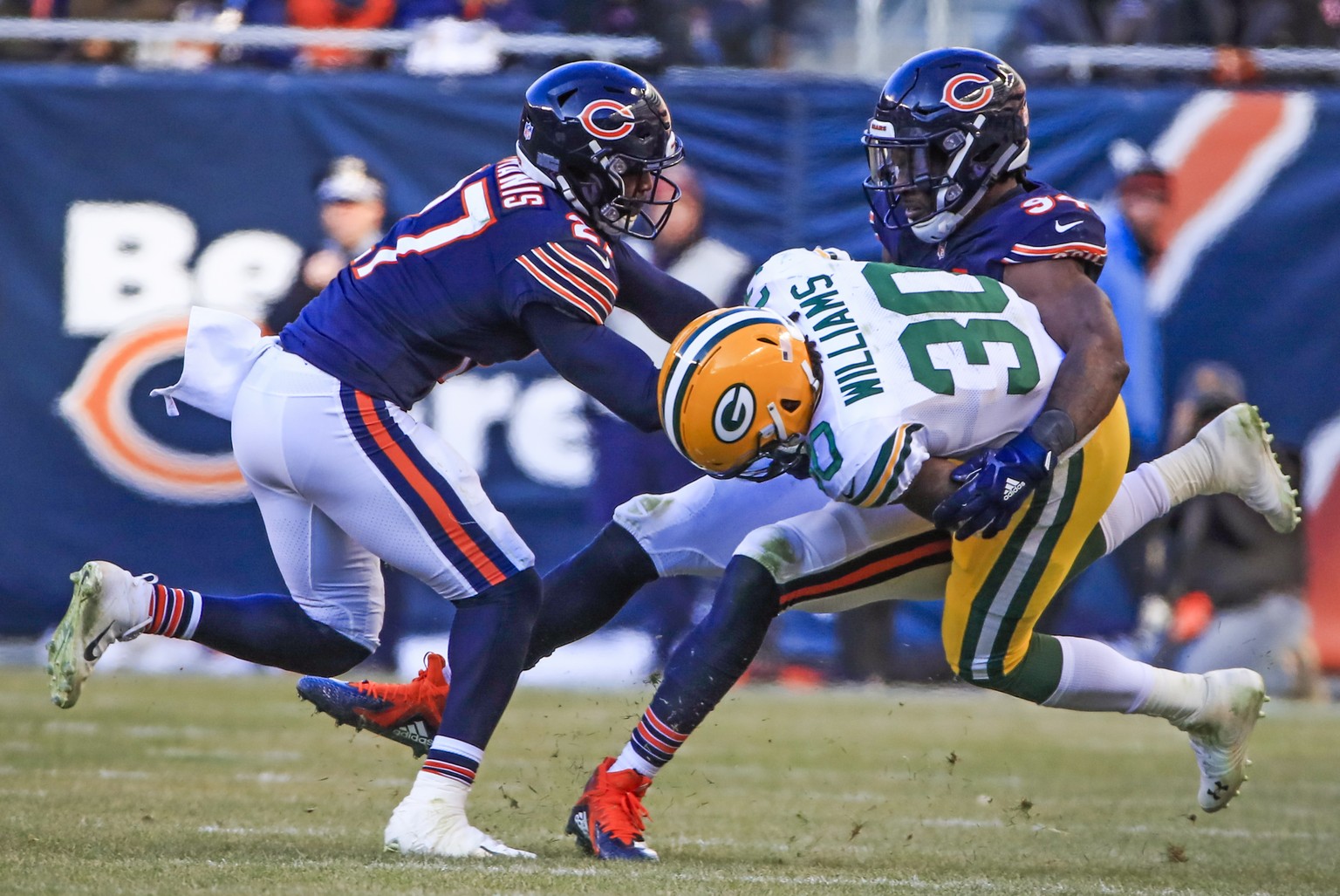 epa07236298 Green Bay Packers running back Jamaal Williams (C) it taken down by Chicago Bears outside linebacker Leonard Floyd (R) and Chicago Bears defensive back Sherrick McManis (L) during the NFL  ...