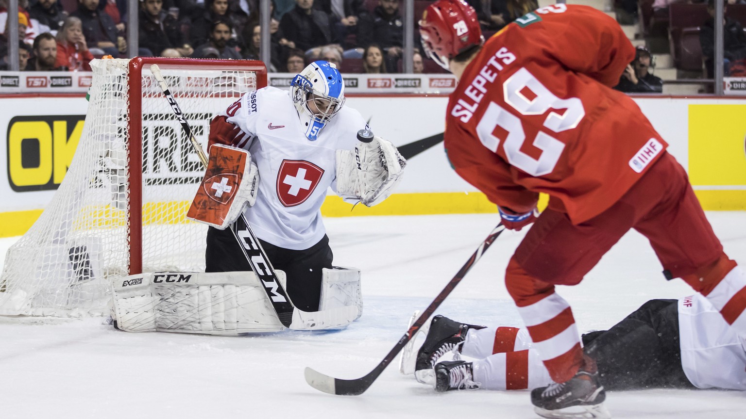 Switzerland goalie Luca Hollenstein, back left, stops Russia&#039;s Kirill Slepets during the first period of the bronze medal game at the world juniorS hockey tournament in Vancouver, British Columbi ...