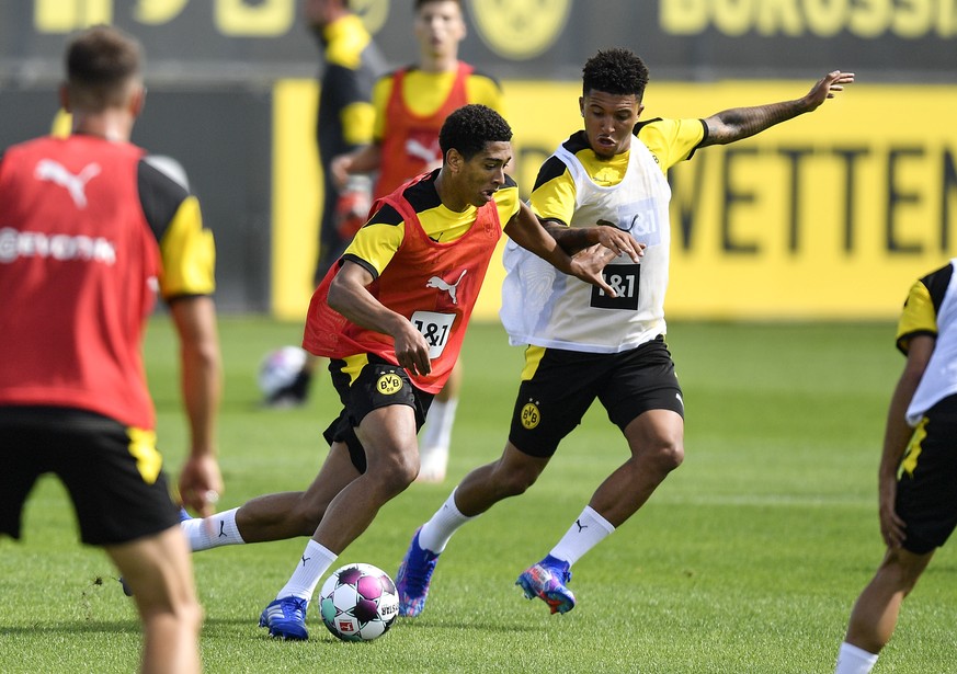 Dortmund&#039;s new English midfielder Jude Bellingham, left, fights for the ball with Jadon Sancho during the first training session of German Bundesliga club Borussia Dortmund at the training ground ...