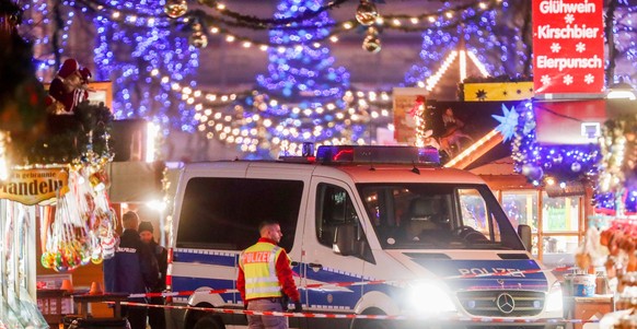 epa06362181 A police car and policemen stand behind barrier tape on an empty Christmas market after it was evacuated by police, in Potsdam, Germany, 01 December 2017. Police said they had found an exp ...