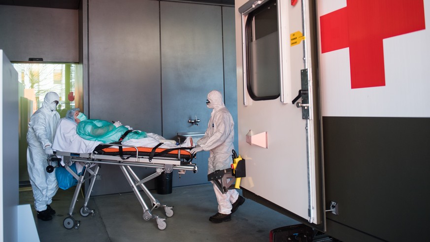 Soldaten der Schweizer Armee beim Transport eines Patienten mit Covid-19 am Eingang der Notaufnahme im Kantonsspital &#039;&#039;La Carita&#039;&#039; in Locarno am Freitag, 13. Maerz 2020. Das Kranke ...