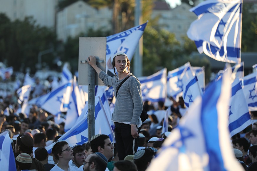 epa09273860 Israelis march with the national flags near the Damascus gate during the Flags March in the old city of Jerusalem, 15 June 2021. The Flag March went on despite threats by the Palestinian m ...