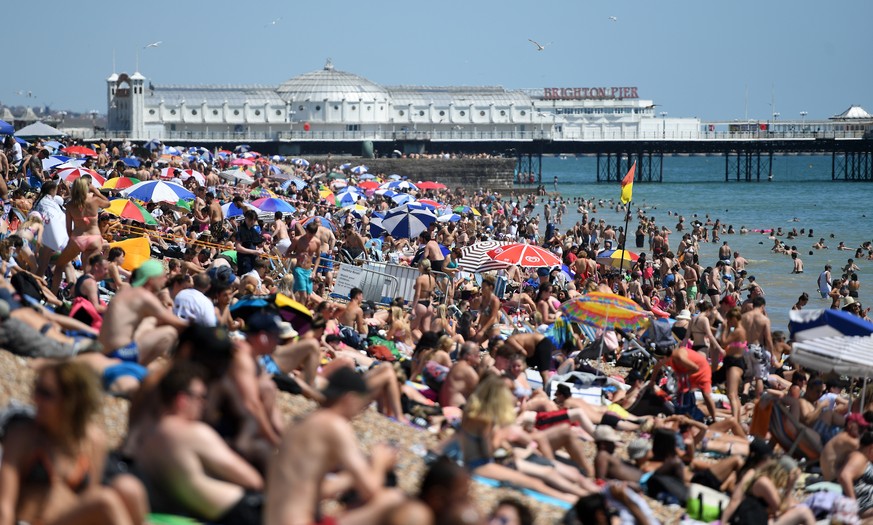 epaselect epa08508620 People soak up the sun on Brighton beach in Brighton, Britain, 25 June 2020. Temperatures of 33C have brought people to the beaches and parks as Britain continues to ease its loc ...