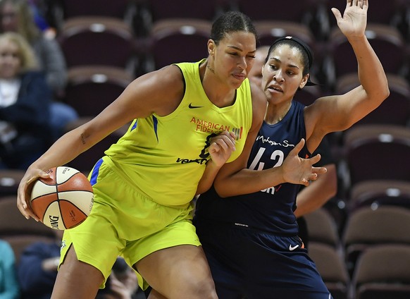 FILE - In this May 8, 2018, file photo, Dallas Wings&#039; Liz Cambage, left, drives against Connecticut Sun&#039;s Brionna Jones during a preseason WNBA basketball game in Uncasville, Conn. Cambage h ...