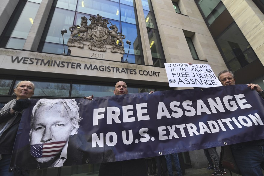 Demonstrators stand outside Westminster Magistrates Court in support of where WikiLeaks founder Julian Assange is due to appear for an administrative hearing, in London, Monday, Jan. 13, 2020. Assange ...