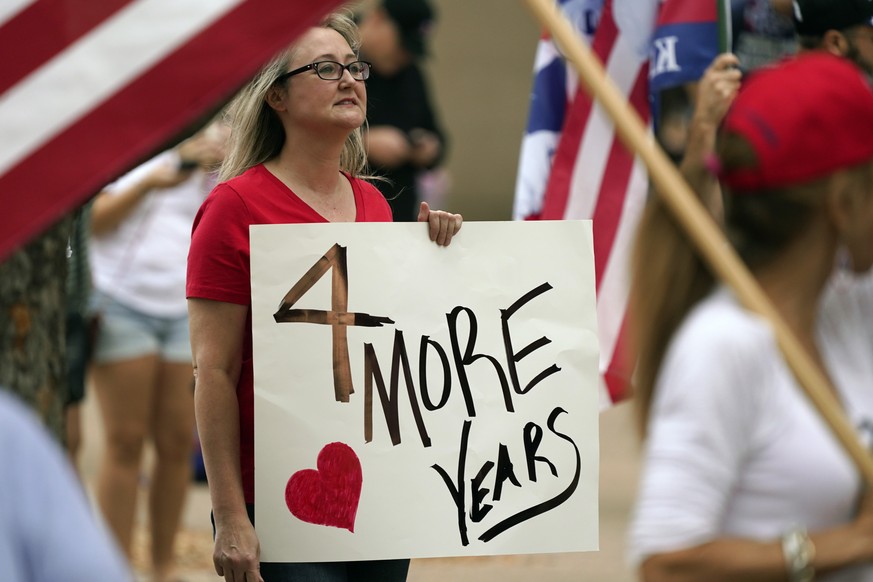 A supporter of President Donald Trump holds a sign during a rally in front of City Hall in Dallas, Saturday, Nov. 14, 2020. (AP Photo/LM Otero)