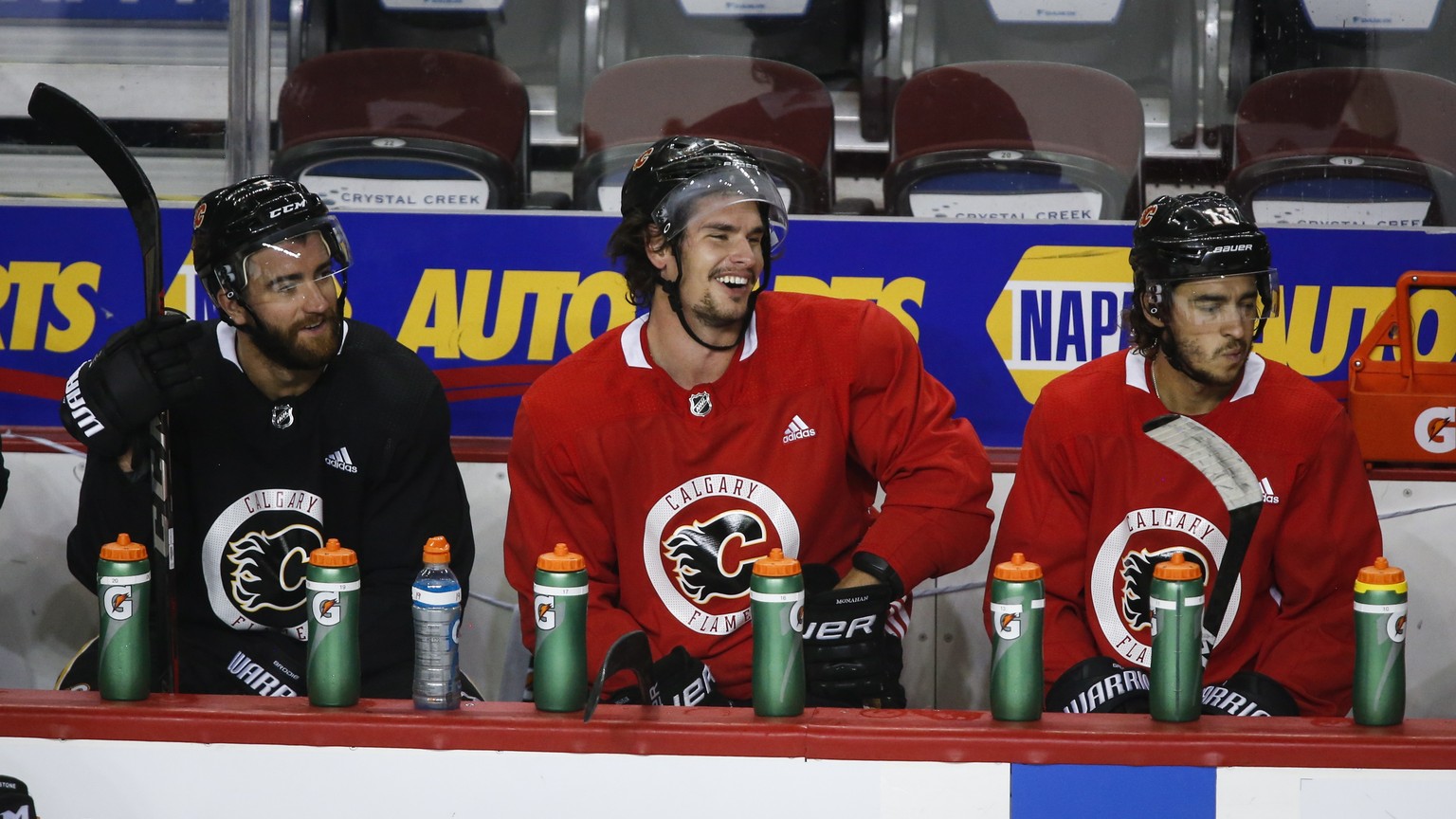 Calgary Flames&#039; Sean Monahan, center, laughs with teammates T. J. Brodie, left, and Johnny Gaudreau during NHL hockey practice in Calgary, Alberta, Thursday, July 23, 2020. (Jeff McIntosh/The Can ...