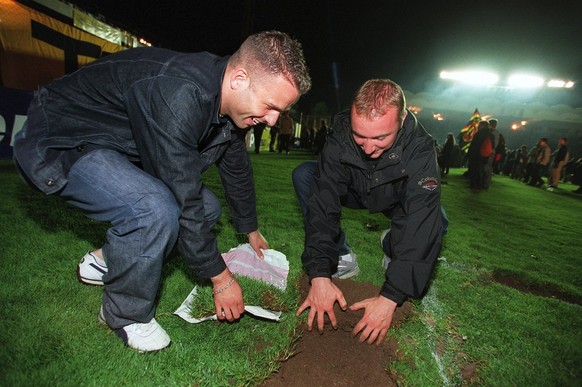 Soccer fans dig up pieces of the lawn of the Wankdorf-Stadium as souvenirs after the stadium&#039;s last game between the Bern Young Boys and the FC Lugano, Saturday July 7, 2001 in Bern, Switzerland. ...