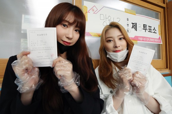 epa08363360 Soo Yoon (L) and Yoon Kyung (R), members of South Korean girl group Rocket Punch, pose for a photo after casting their ballots for the general elections at a polling station in Seoul, Sout ...