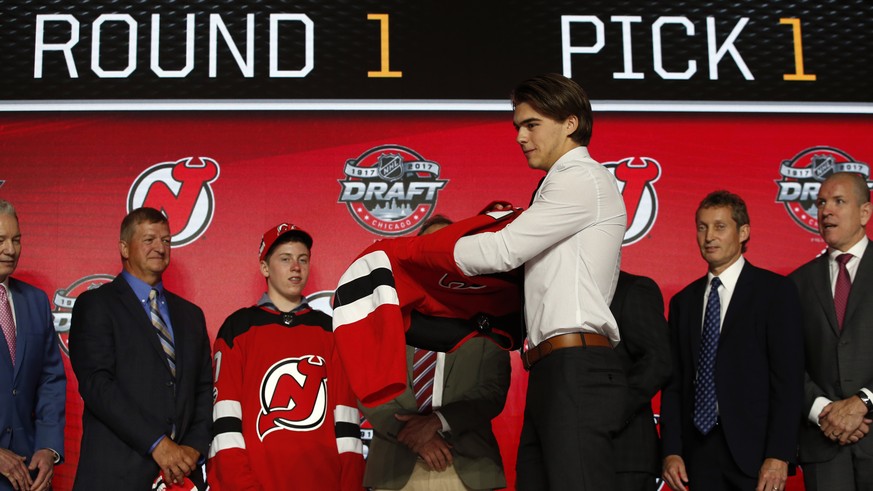 Center Nico Hischier, chosen by the New Jersey Devils in the first round of the NHL hockey draft, puts on a jersey Friday, June 23, 2017, in Chicago. (AP Photo/Nam Y. Huh)