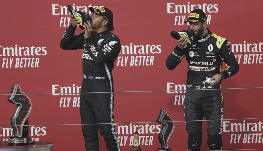 epa08790945 Winner British Formula One driver Lewis Hamilton of Mercedes-AMG Petronas (L) and third Australian Formula One driver Daniel Ricciardo of Renault (R) drink champagne from their shoes after ...