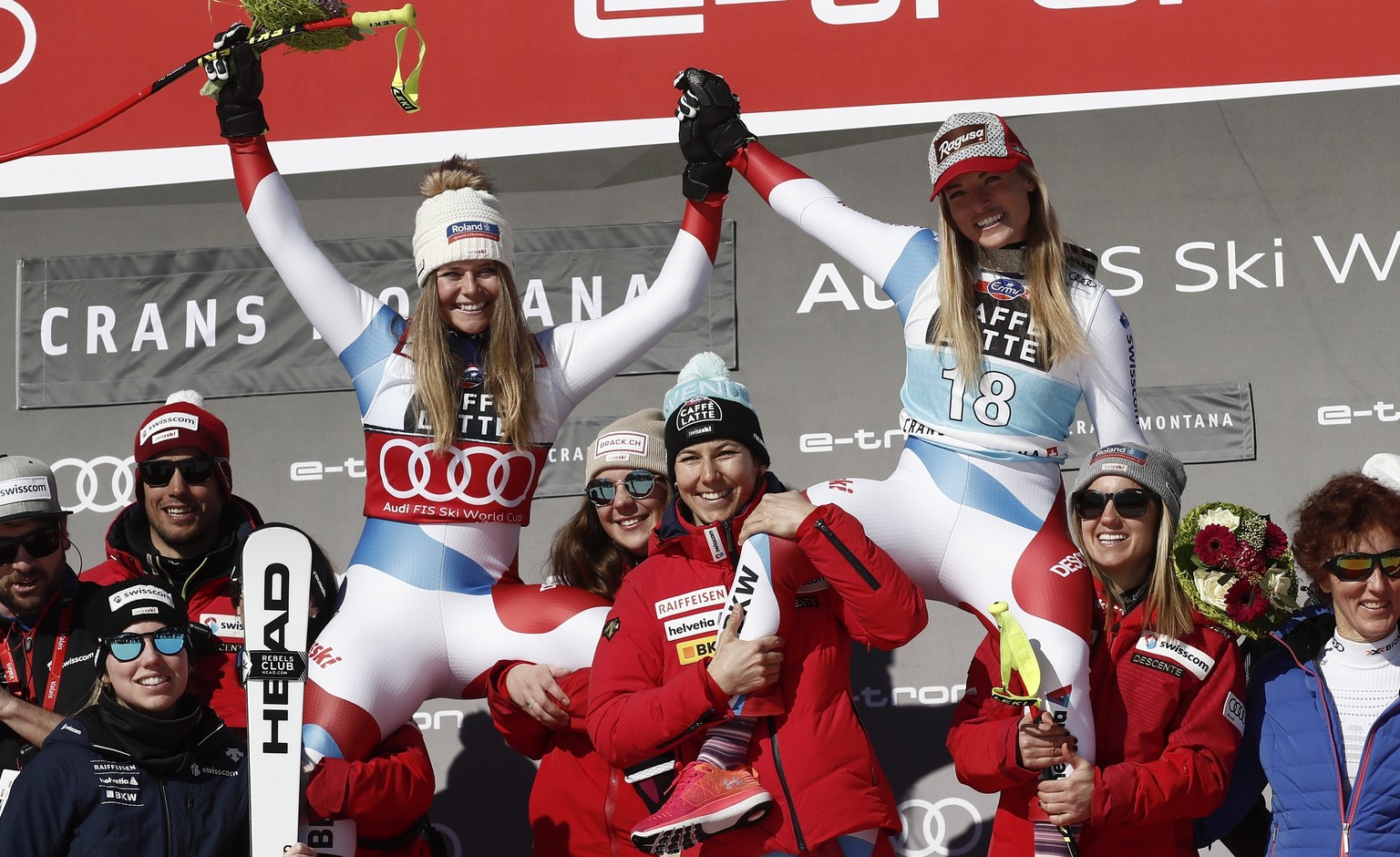 Switzerland&#039;s Lara Gut-Behrami, winner of an alpine ski, women&#039;s World Cup downhill, top right, celebrates with second-placed Switzerland&#039;s Corinne Suter, and the Swiss team, in Crans M ...