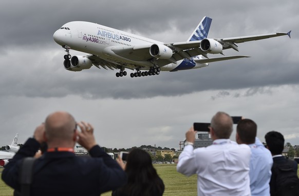 epa07368932 (FILE) - Plane enthusiasts watch an Airbus A-380 during a flight demonstration at the Farnborough International Air show in Farnborough, Britain, 11 July 2016 (reissued 14 February 2019).  ...