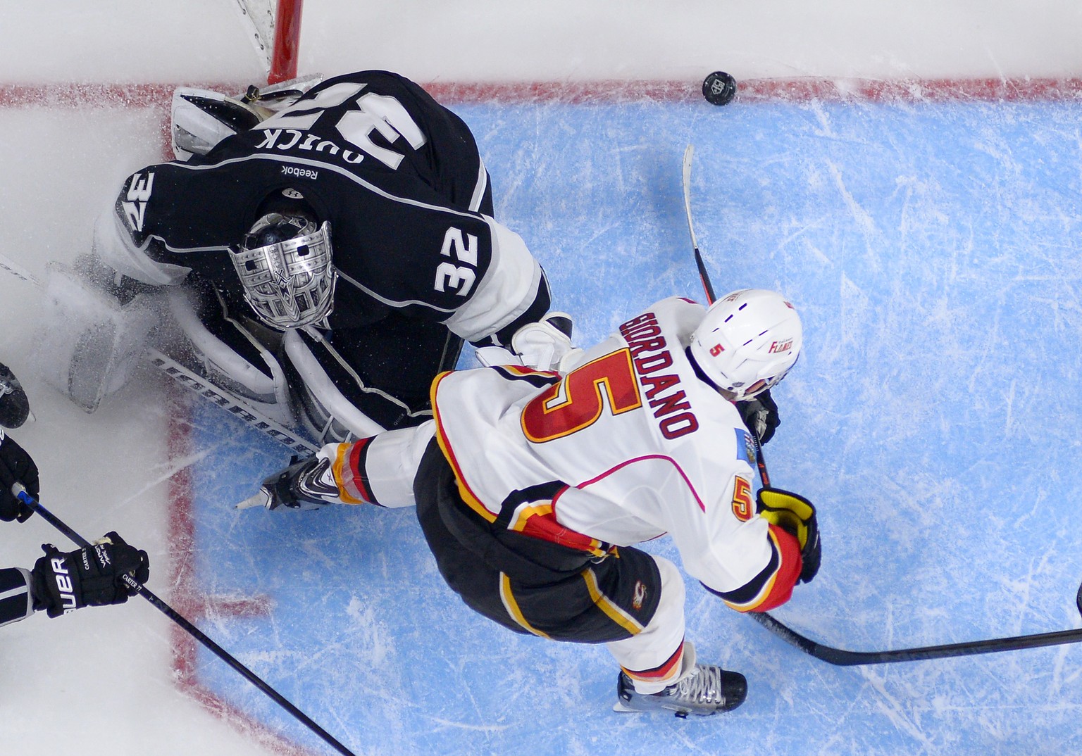 Calgary Flames defenseman Mark Giordano, right, scores a game-winning goal on Los Angeles Kings goalie Jonathan Quick during the overtime period of an NHL hockey game, Monday, Dec. 22, 2014, in Los An ...