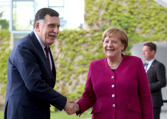 epa07554160 German Chancellor Angela Merkel (R) welcomes Libyan Prime Minister Fayez Al Sarraj (L) for a meeting at the Chancellery in Berlin, Germany, 07 May 2019. EPA/HAYOUNG JEON