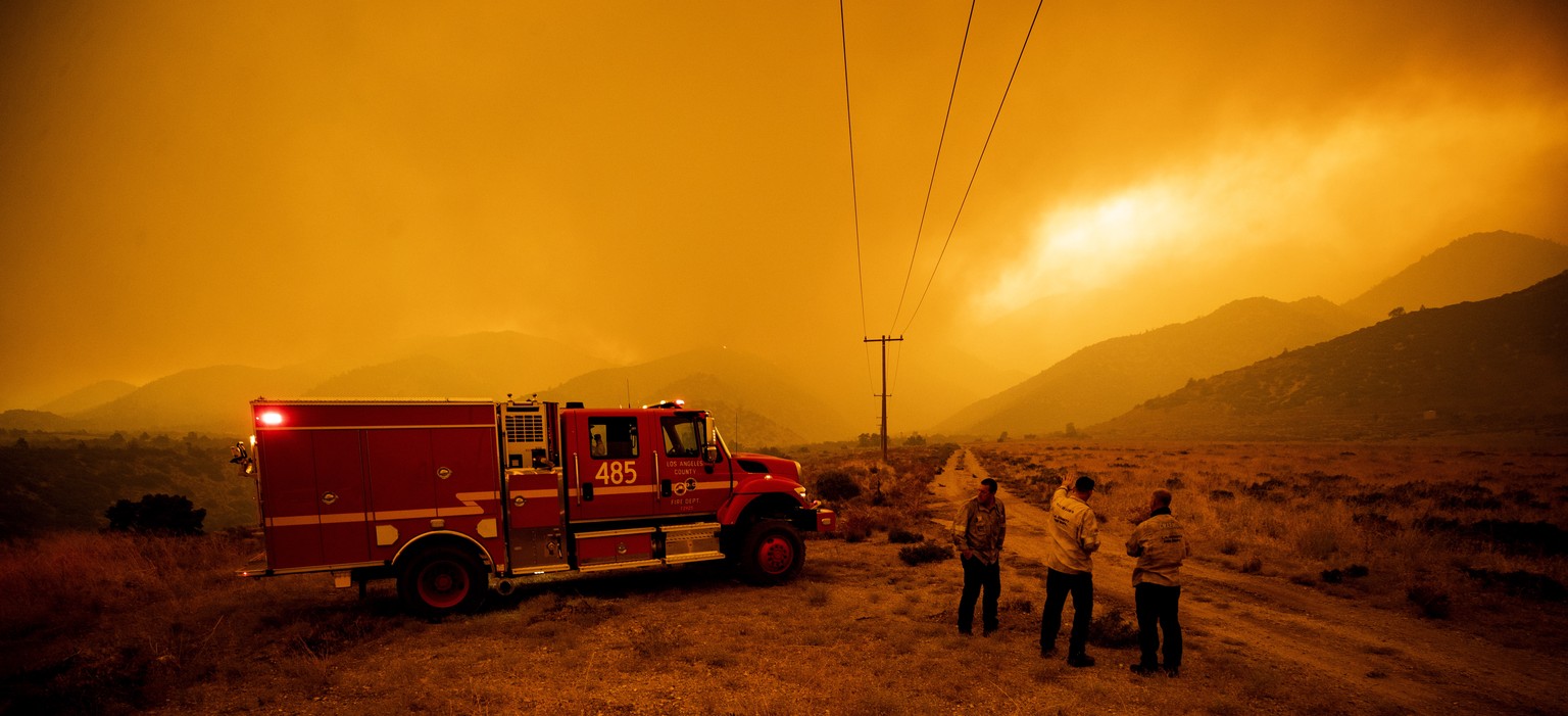 epa08677670 Firefighters assess the evolution of the Bobcat Fire as it continues to burn in the Angeles National Forest near Juniper Hills, north East of Los Angeles, California, USA, 17 September 202 ...