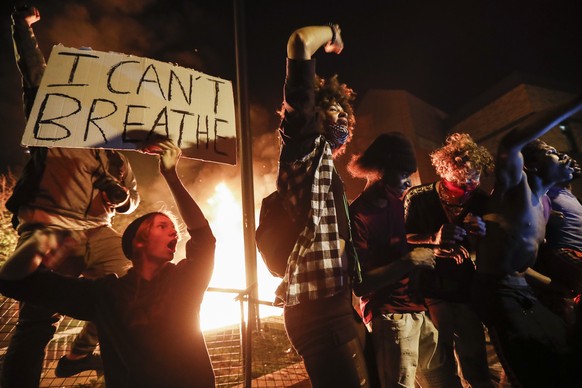 FILE - In this May 28, 2020, protesters demonstrate outside of a burning Minneapolis 3rd Police Precinct in Minneapolis. For most police officers going on trial, the argument that they made a split-se ...