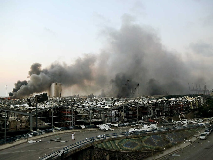 ARCHIV - Rauch steigt nach einer Explosion über einem Gebäude am Hafen auf. Mehr als vier Monate nach der verheerenden Explosion im Hafen von Beirut hat ein libanesischer Ermittlungsrichter Anklage ge ...