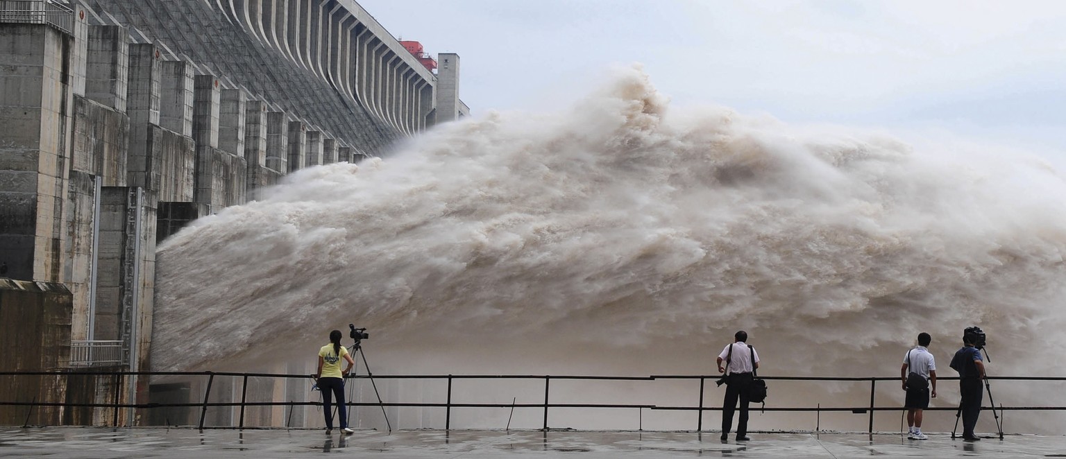 FILE - In this file photo taken July 20, 2010 and released by China&#039;s Xinhua news agency, journalists take photos as flood water is released from the Three Gorges Dam&#039;s floodgates in Yichang ...