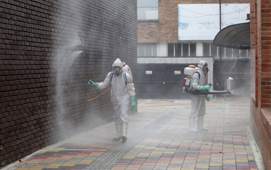 Worker in full protective gear amid the new coronavirus pandemic disinfect an alleyway at Corabastos, one of Latin America&#039;s largest food distribution centers, in Bogota, Colombia, Tuesday, June  ...