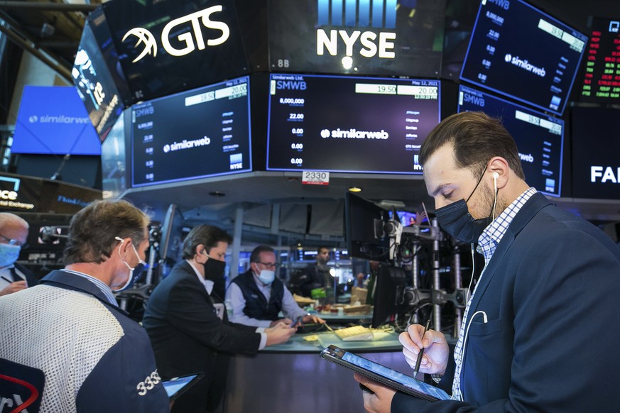 In this photo provided by the New York Stock Exchange, traders work around stock monitoring systems on the trading floor, Wednesday, May 12, 2021, in New York. Inflation worries rattled Wall Street on ...