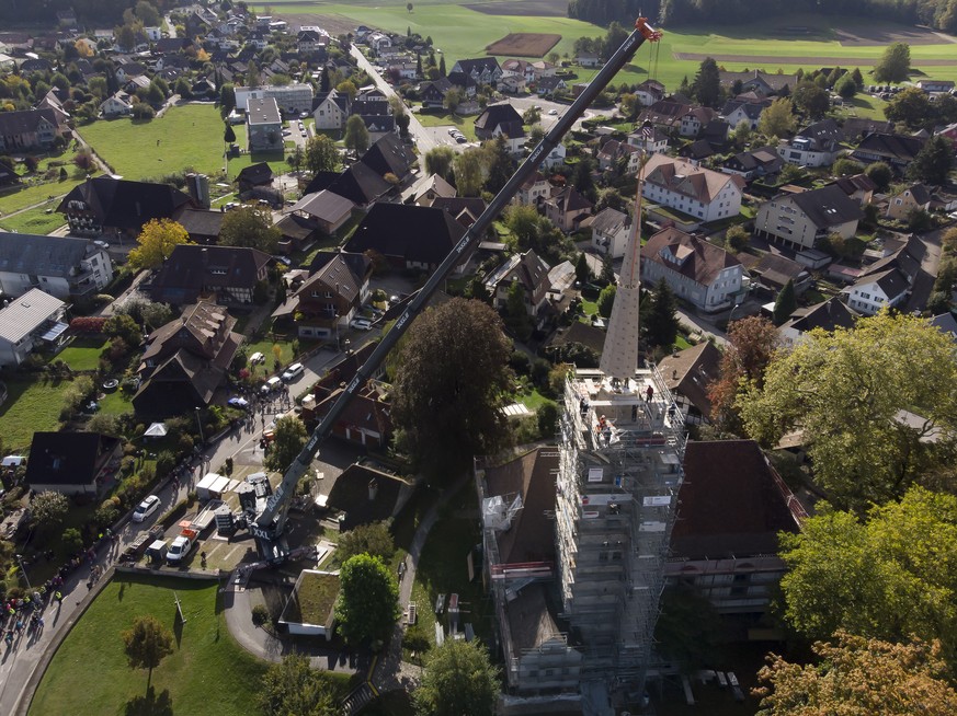 Der zweite Teil der Turmspitze wird mit einem Autokran auf den Kirchturm montiert, am Donnerstag, 8. Oktober 2020 in Herzogenbuchsee. Das Feuer im Kirchturm war am 24. Dezember 2019 ausgebrochen. (KEY ...