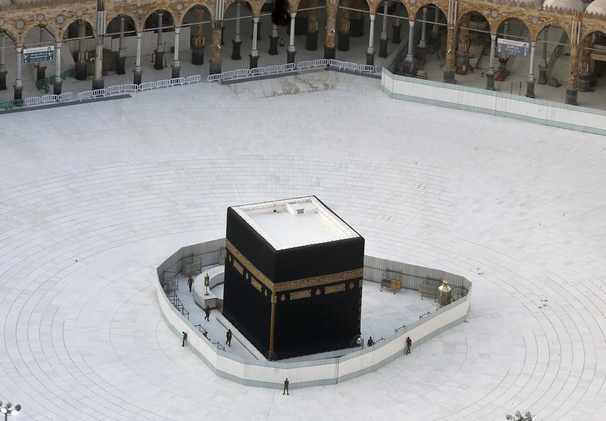 Saudi policemen guard the the Kaaba, the cubic building at the Grand Mosque, in the Muslim holy city of Mecca, Saudi Arabia, Friday, March 6, 2020. Saudi Arabia emptied Islam&#039;s holiest site for w ...
