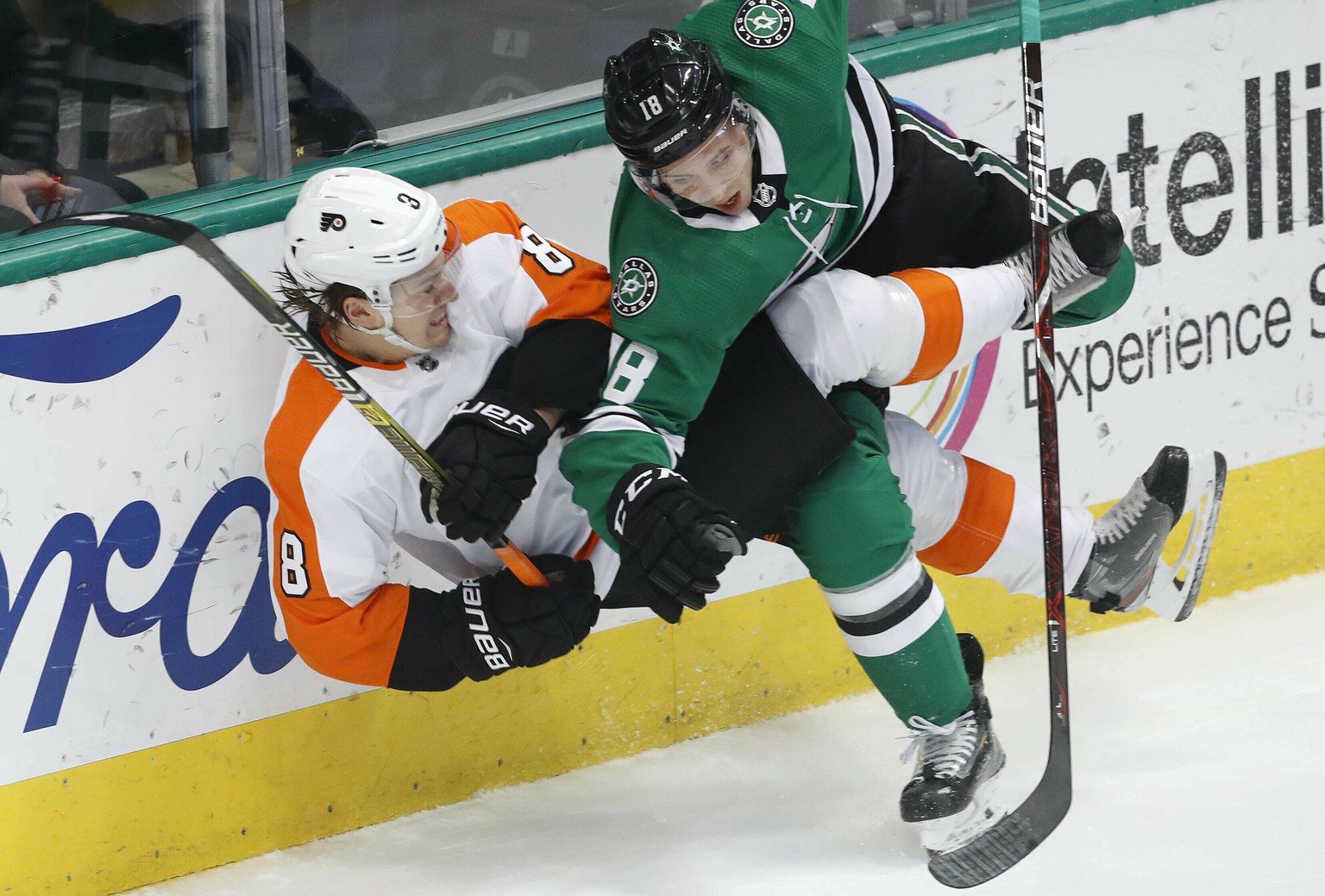 Philadelphia Flyers right wing Ryan Hartman, left, and Dallas Stars center Tyler Pitlick, right, crash the boards during the first period of an NHL hockey game in Dallas, Tuesday, April 2, 2019. (AP P ...
