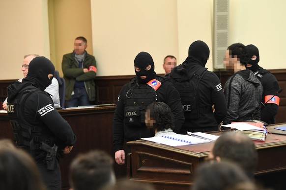 epa06497661 Prime suspect in the November 2015 Paris attacks Salah Abdeslam (C, seated) sits beside his alleged accomplice Sofiane Ayari (R, standing) as they are surrounded by Belgian special police  ...