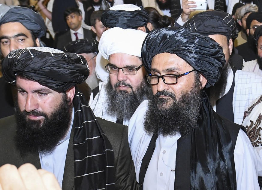 epa08260798 Taliban co-founder Mullah Abdul Ghani Baradar (R) leaves after signing an agreement with the United States during a ceremony in Doha-Qatar on 29 February 2020 The United States and the Tal ...
