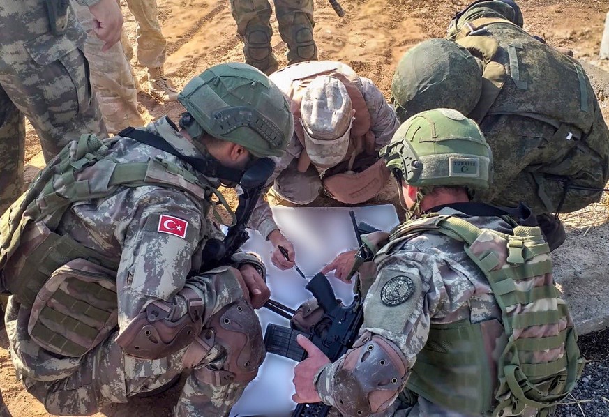 epa07974033 A handout photo made available by the Turkish Defense Ministry press office shows Turkish soldiers meeting with Russian soldiers during a patrol in Ayn Al-Arab, in Northern Syria, 05 Novem ...