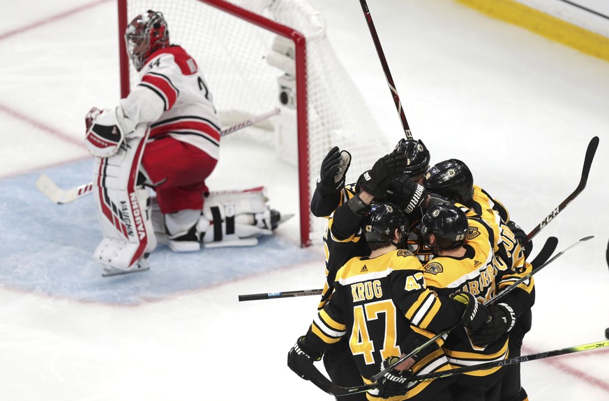 Boston Bruins&#039; Marcus Johansson is surrounded by teammates after his goal against Carolina Hurricanes goaltender Petr Mrazek (34), of the Czech Republic, during the third period in Game 1 of the  ...