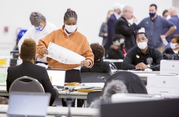 epa08798699 Absentee Ballots are certified and then counted at TCF Center, in Detroit, Michigan, USA, 04 November 2020. The 2020 Presidential Election result remains undetermined as votes continued to ...
