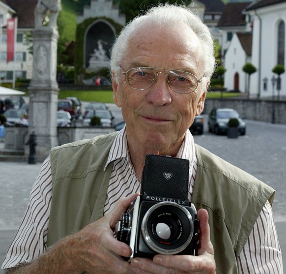 Der ehemalige Polizist und Fotograf Arnold Odermatt posiert mit seiner Kamera, am Freitag, 27. Mai 2005 auf dem Dorfplatz in Stans. Der Nidwaldner Fotograf Arnold Odermatt feiert am Sonntag, 29. Mai 2 ...