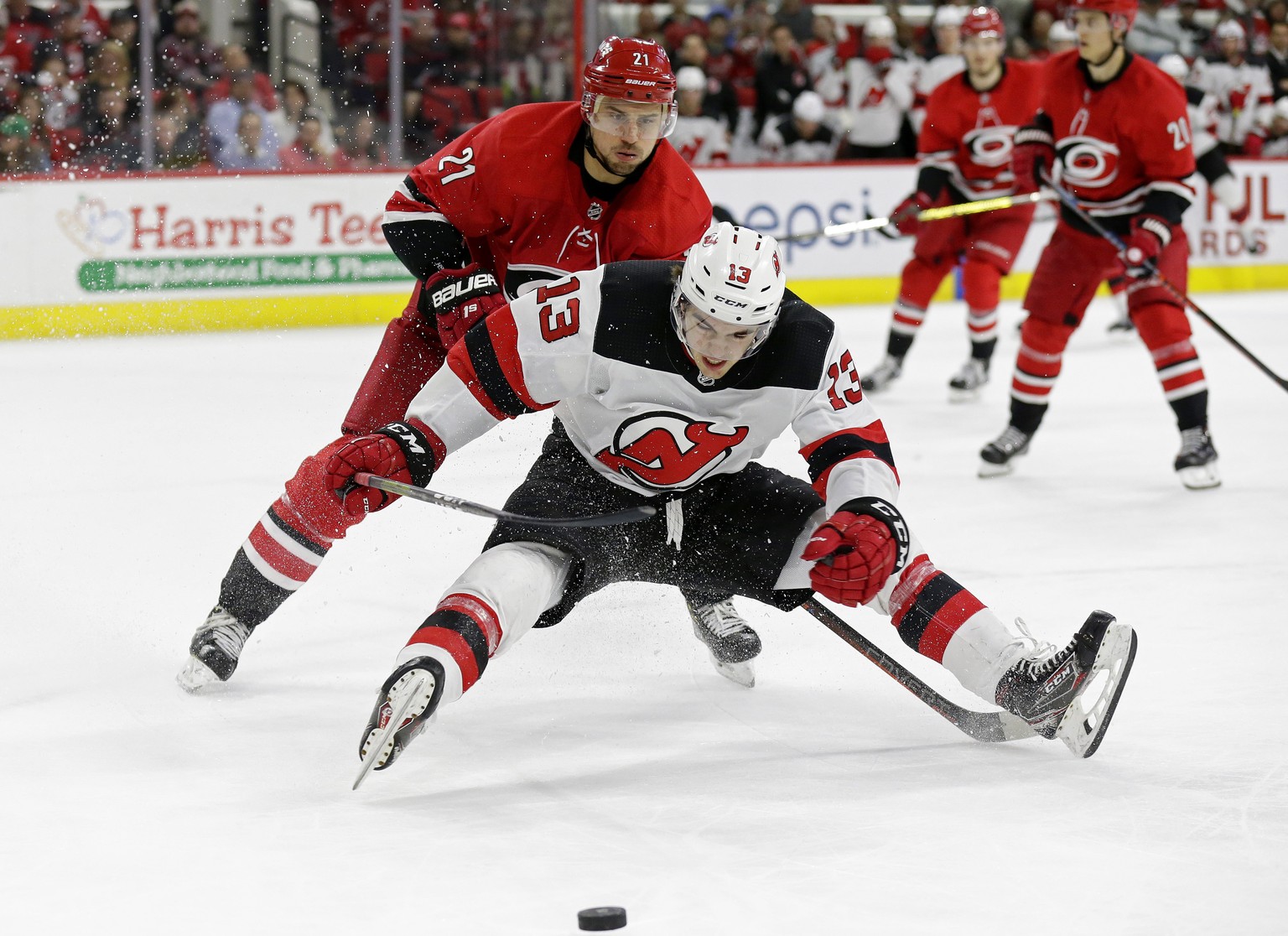 Carolina Hurricanes&#039; Nino Niederreiter (21), of the Czech Republic, and New Jersey Devils&#039; Nico Hischier (13), of Switzerland, chase the puck during the second period of an NHL hockey game i ...