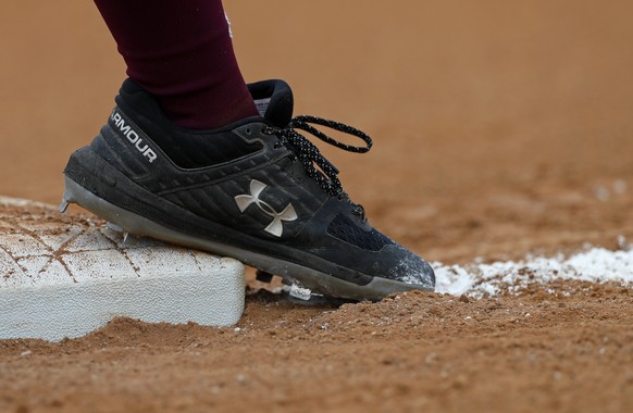FILE - In this May 3, 2019, file photo a Texas Southern University&#039;s softball player&#039;s Under Armour cleats touch the third base bag during a NCAA softball game in Houston. Under Armour last  ...