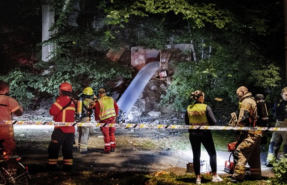 Police and rescue workers are seen outside the entrance of a former underground emergency shelter, which was used for an illegal rave party, in central Oslo, Sunday, Aug, 30, 2020. At least 27 people  ...