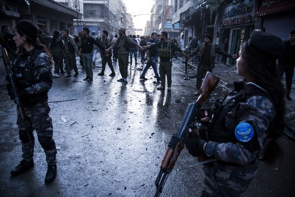 Local forces secure the area after a car bomb blast in the city of Qamishli, northern Syria, Monday, Nov. 11, 2019. Three car bombs went off Monday in then city killing several and wounding tens of pe ...