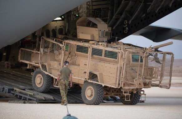epa07964615 A handout photo made available by the US Department of Defense shows an army vehicle being loaded onto a C-17 Globemaster III in support of the deliberate withdrawal of Coalition forces fr ...