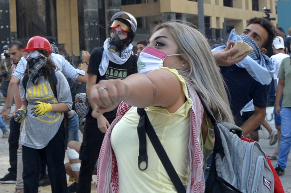 epa08595708 Lebanese anti-government protesters throw stones at security forces at one of the roads leading to the parliament in Beirut, Lebanon, 10 August 2020. Lebanese government resigned amid cont ...