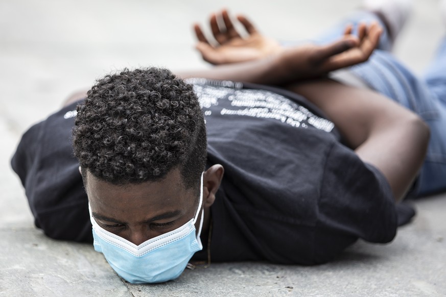 epa08763928 YEARENDER 2020 .BLACK LIVES MATTER..A young man lies on the ground for 8 minutes and 46 seconds during a demonstration against racism in Bern, Switzerland, 11 July 2020. Eight minutes 46 s ...
