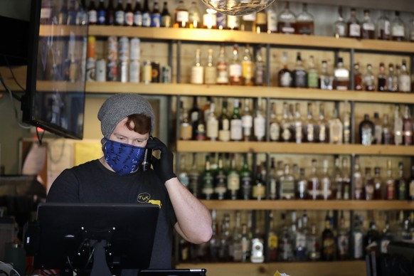 John Randall, general manager at Salt + Smoke restaurant, wears a mask and gloves as he takes an order over the phone Friday, April 10, 2020, in St. Louis. Many restaurants like Salt + Smoke have star ...