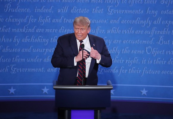 epa08707162 US President Donald J. Trump puts away a mask as he participates in the first 2020 presidential election debate at Samson Pavilion in Cleveland, Ohio, USA, 29 September 2020. The first pre ...