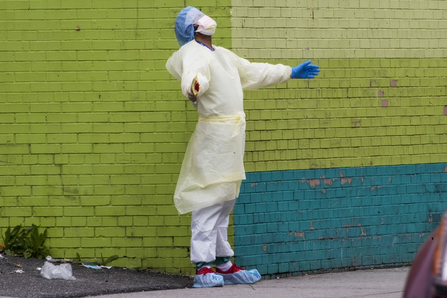 A medic of the Elmhurst Hospital Center medical team reacts after stepping outside of the emergency room, Saturday, April 4, 2020, in the Queens borough of New York. The new coronavirus causes mild or ...