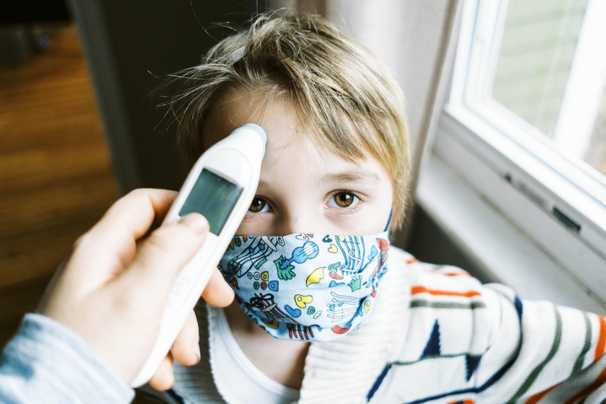 Child with fever wearing mask in home getting temperature taken North Brookfield, MA, United States PUBLICATIONxINxGERxSUIxAUTxONLY CR_SEBU201204A-586635-01 ,model released, Symbolfoto